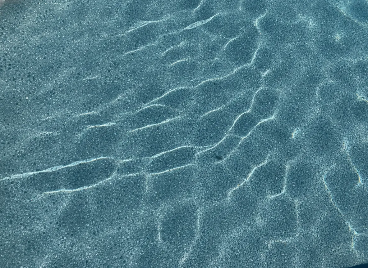 Close-up of a pebble aggregate pool finish under clear water